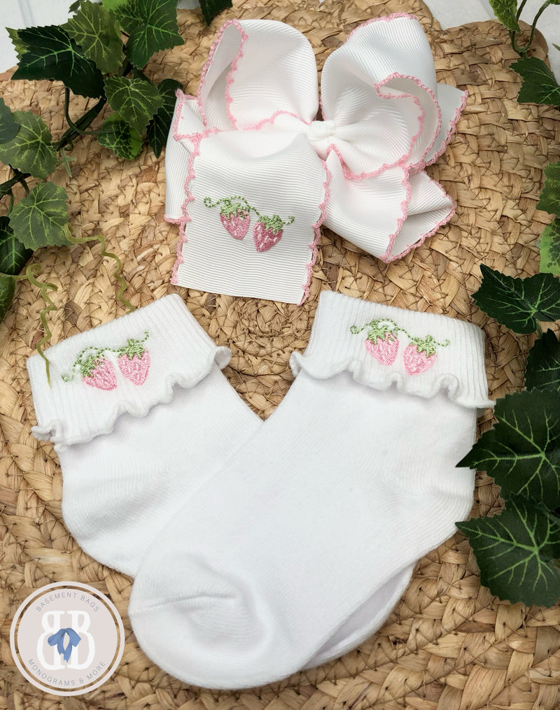 White socks with strawberry design and matching hair bow. 